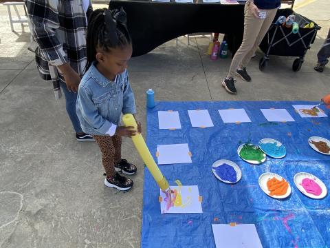 Journee Posey, 4, mimics an elephant painting with its trunk during Animal Biomechanics Day at Zoo Atlanta. (Photo Renay San Miguel). 